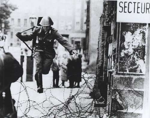 La celebra foto che immortala il sodato della DDR che fugge ad ovest durante la costruzione del muro. 