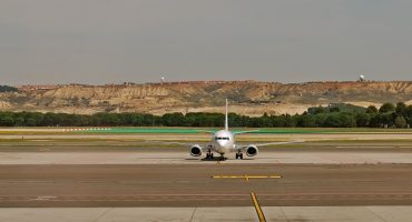 Un passeggero ritardatario insegue il suo aereo sulla pista di atterraggio